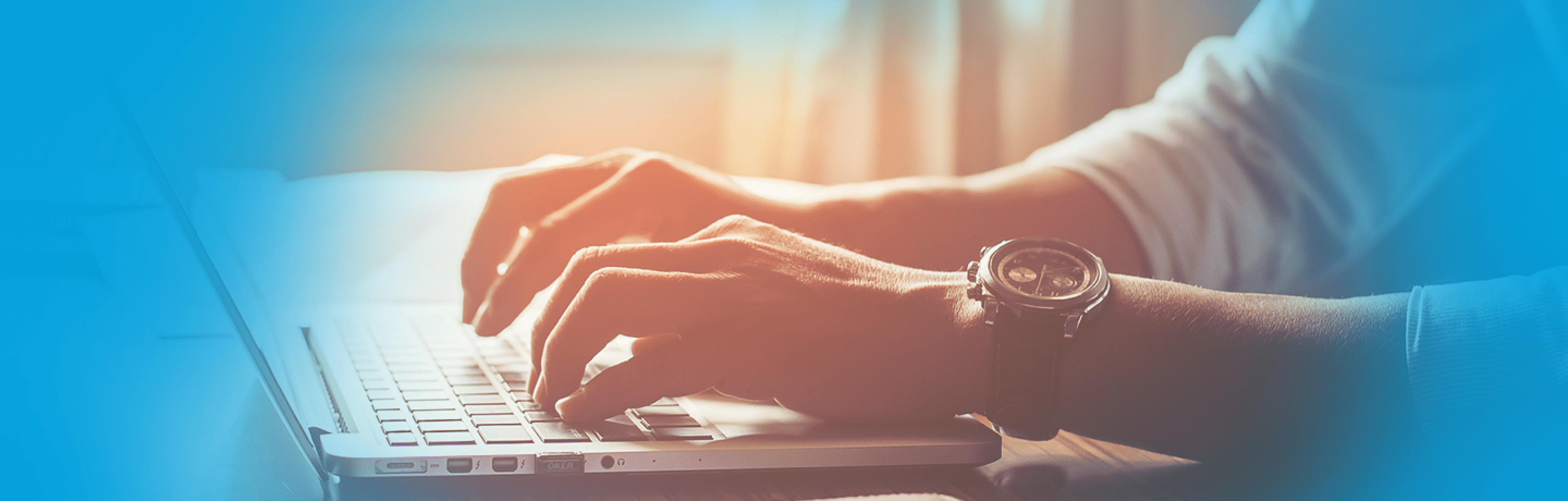 Hände eines Mannes auf einer Tastatur, links und rechts umgeben von blauen Farbverläufen